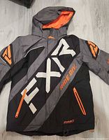 Front view of FXR jacket showing colors, graphics and pockets