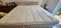 Top view of white quilted king mattress topper on bed
