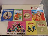 Eight French children’s books laid out on white table