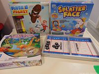 Group shot of all four games showing boxes and Fastrack board