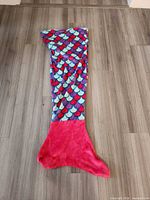 Full view of mermaid tail blanket front side showing scale pattern body and pink fin