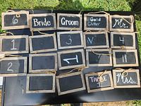 Front view of 16 of the chalkboard signs showing wood frames, rope hangers, chalk writing