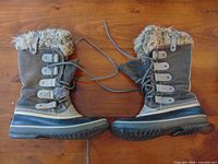 Side view of pair of brown/gray Sorel Joan of Arctic winter boots showing full exterior and laces