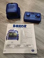 Robot, remote and instruction manual laid out on floor
