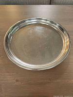 Top view of stainless steel round tray showing overall condition and raised rim