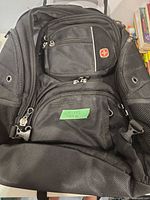 Front view showing red cross logo, multiple compartments, mesh pocket