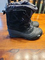 Left side view of both boots showing suede upper, rubber shell, laces, logo