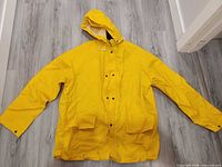 Front view of yellow raincoat laid flat