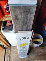 Carton standing upright with planks showing and Voila branding
