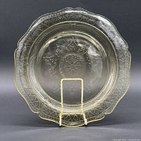 Front view of amber Patrician Spoke plate on stand