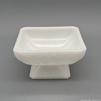 Angle view of square milk glass compote showing pedestal and embossing