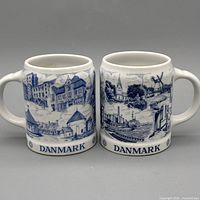 Front view of both BYGDO mugs showing Danish scenery and DANMARK text