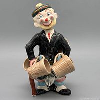 Front view of ceramic kilted clown decanter with four mugs attached