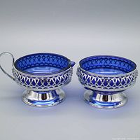 Pair of cobalt glass creamer and sugar bowl in chrome mounts, front view