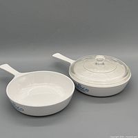 Top view of open skillet and lidded casserole, showing blue cornflower motif