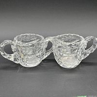 Front view of the matching cut glass creamer and sugar bowl showing overall design