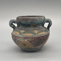 front view showing turquoise glaze, ochre motifs and wear