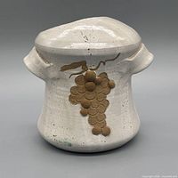 front view showing grape cluster decoration and lid