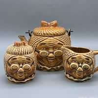 Front view of teapot, creamer and sugar jar showing overall design