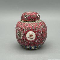 Front view of ginger jar showing red ground, shou roundel and floral scrolls
