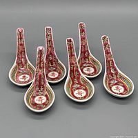 Full set of six Chinese famille rose soup spoons displayed upright.