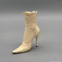 Left side view of cream ivory lace stiletto boot figurine