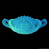 dish glowing green under UV light, highlighting manganese fluorescence