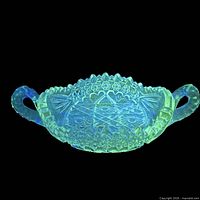 Candy dish glowing green under UV light highlighting manganese content