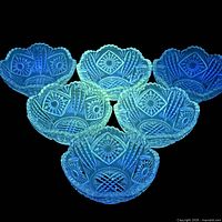 Six bowls fluorescing under UV light