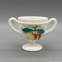 Front view showing hand-painted peaches design, handles, beaded rim, pedestal base