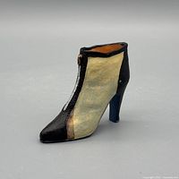 Left profile of two-tone resin ankle boot figurine