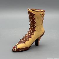 Side view of miniature Victorian lace-up boot figurine showing color, lattice overlay and floral details