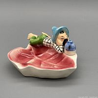 Top angled view showing full ashtray, figure, jug, leaf bowl