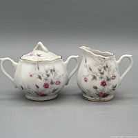 Front view of lidded sugar bowl and creamer set