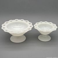 both milk glass compotes side by side showing size difference and design