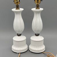 Full view of both matching milk glass hobnail table lamps with cords visible