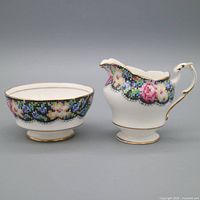 creamer and sugar bowl front view showing mosaic floral band and gold trim