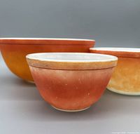Three Pyrex bowls grouped, showing exterior colours and wear