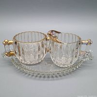 Full view of creamer, sugar bowl and underplate showing design and trim