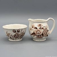 Front view of creamer and sugar showing floral pattern