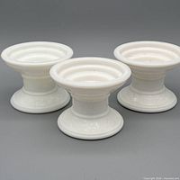 Three matching milk glass candle holders, top view
