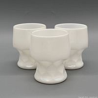 Three white milk glass goblets front group view