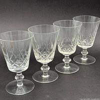 Four matching crystal wine glasses in a row