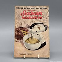 Front cover of Sunbeam Mixmaster manual showing mixer and cake batter