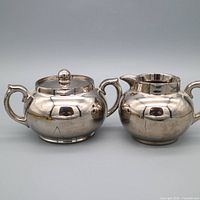 Front view of sugar bowl with lid and creamer showing overall design