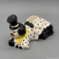 Front angle of ceramic clown tape dispenser showing face, top hat, tape slot at back