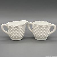 front view of matching white hobnail creamer and sugar bowl