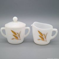 Front view showing wheat motif on creamer and covered sugar bowl
