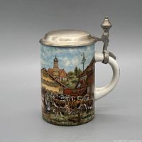 Left view showing hinged pewter lid and main village scene