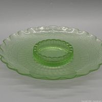 Top view showing entire green glass tray, scalloped rim, central circular well